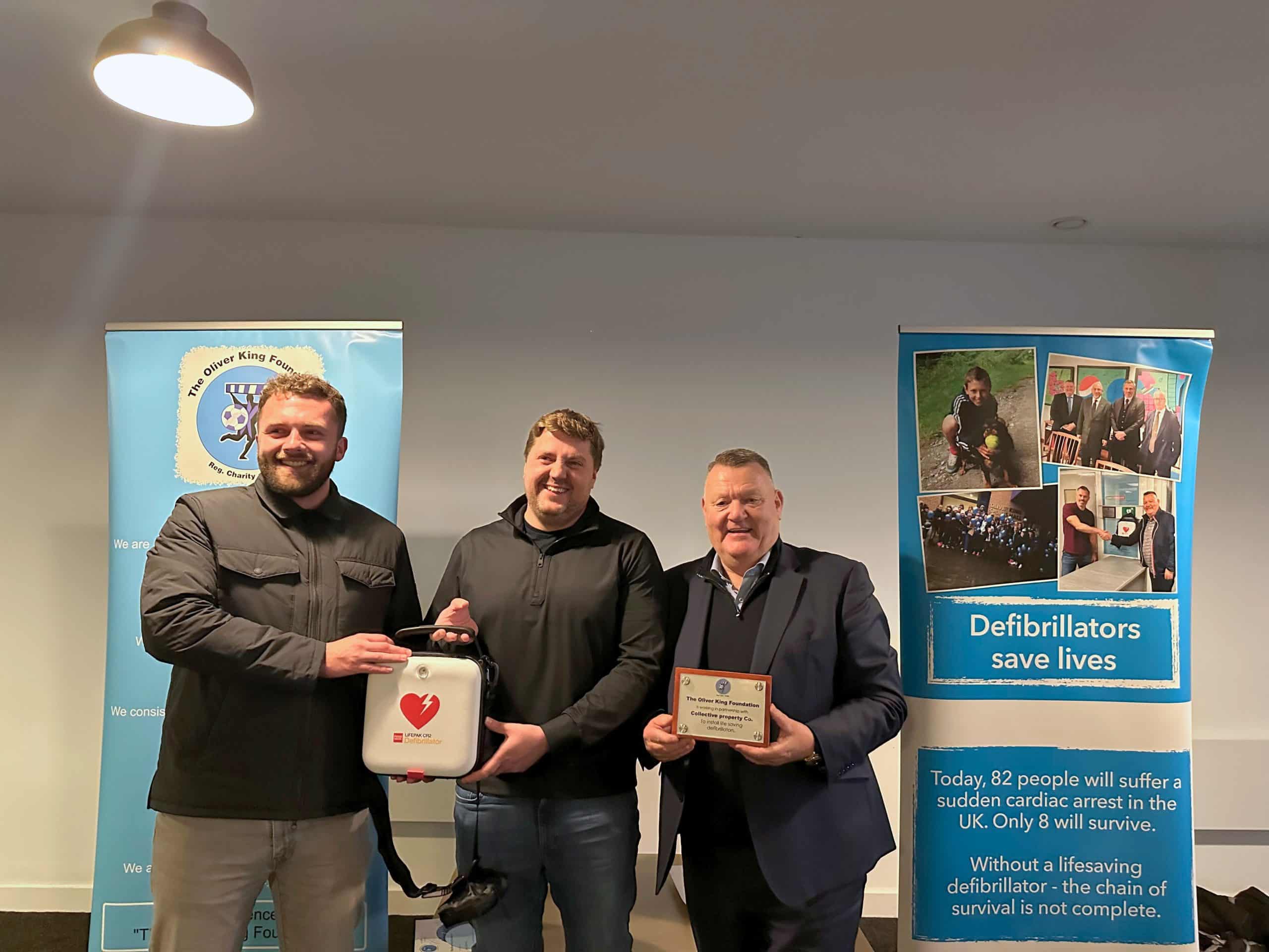 Dave King and Collective Directors holding new defibrillator