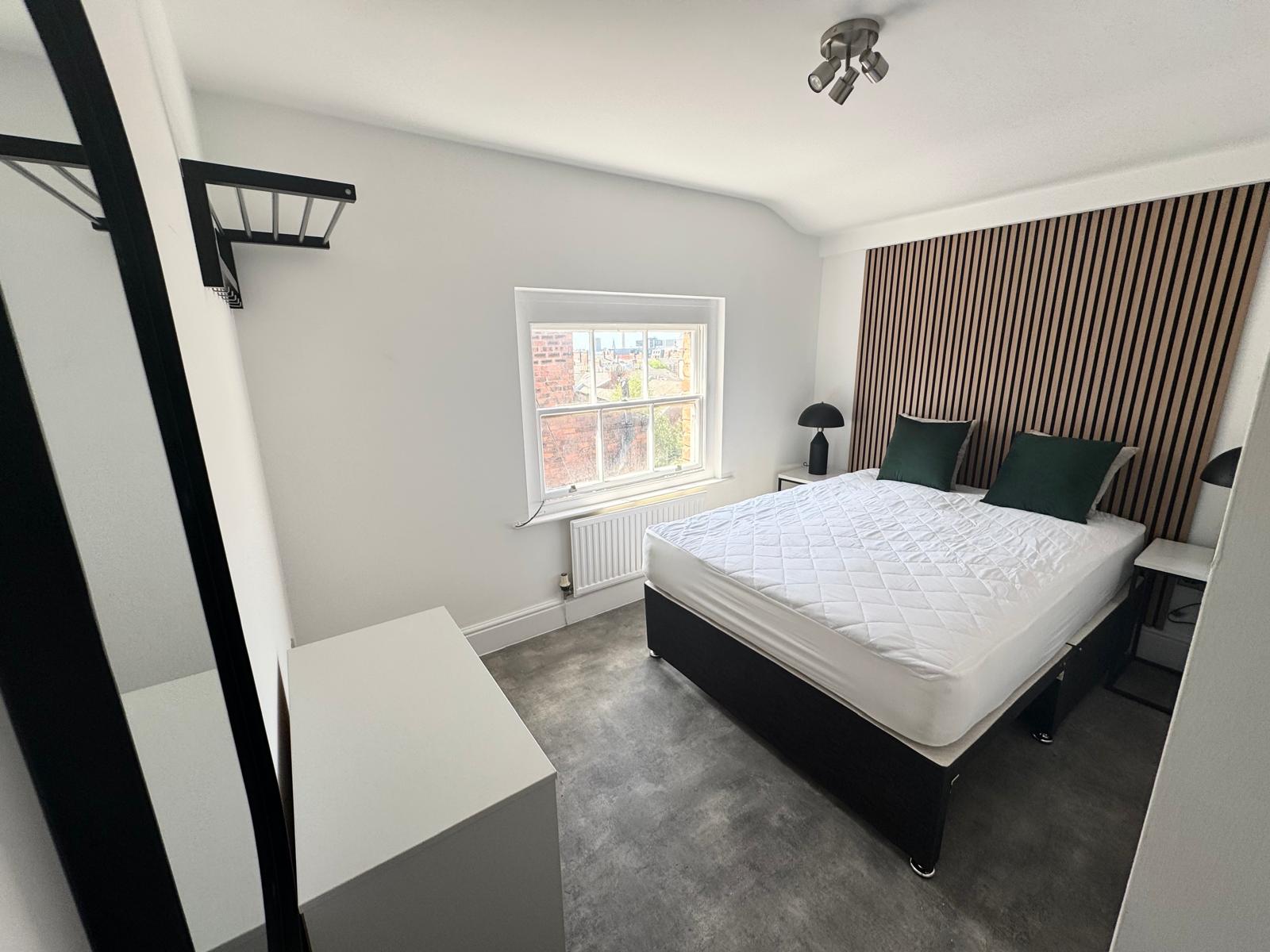 refurbished, modern bedroom with wooden wall panels